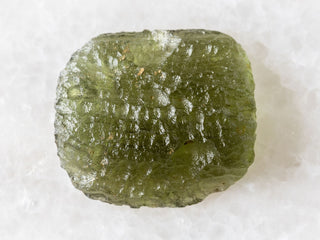 Rough green crystal specimen on a white background.